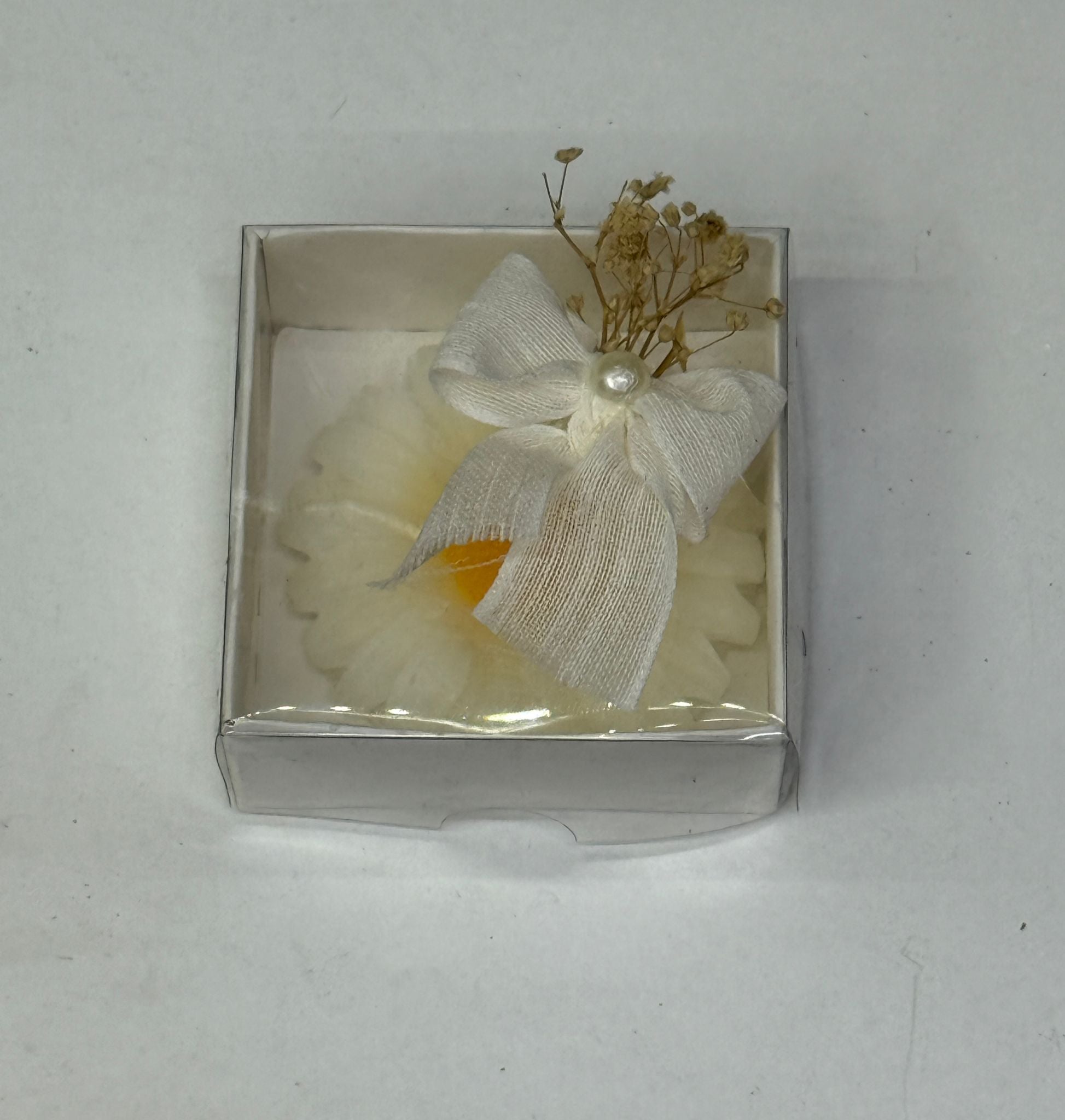 Weiße Blütenkerze in Geschenkbox mit Schleife und Trockenblumen