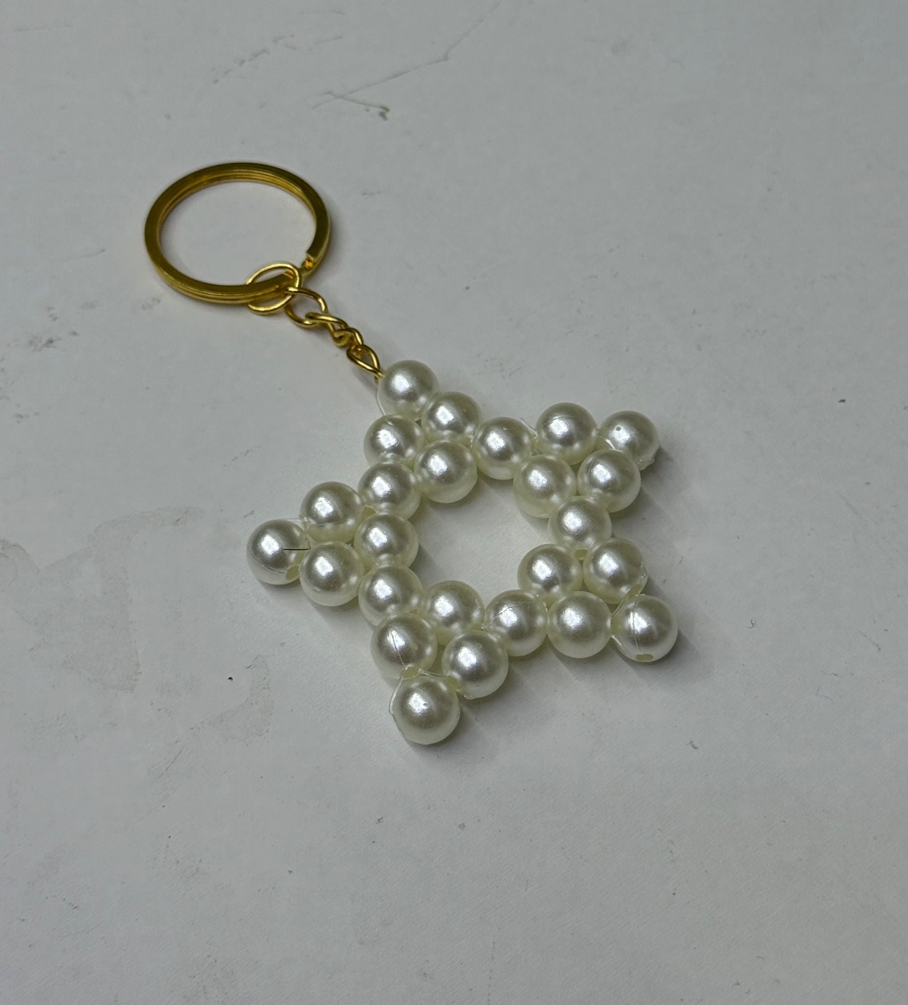 Sternförmiger Perlen-Schlüsselanhänger mit goldfarbenem Ring