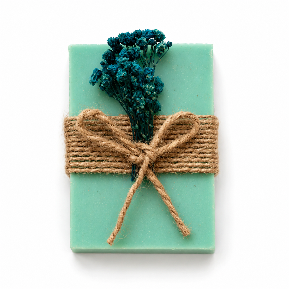 Lavendelseife in Tuerkis mit Juteband und blauen Trockenblumen