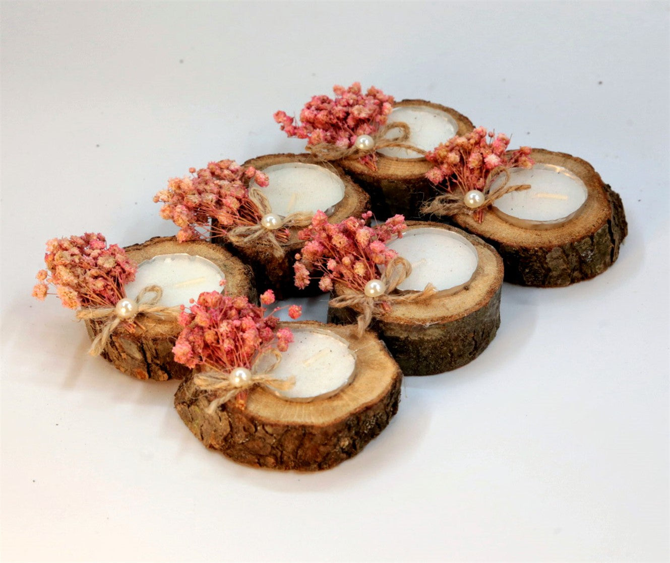 Rustikale Teelichtkerze in Holzscheibe mit rosa Trockenblumen und Perle