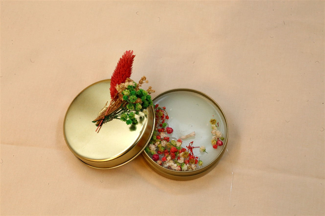 Kerze in goldener Metalldose mit Trockenblumen und Deckel