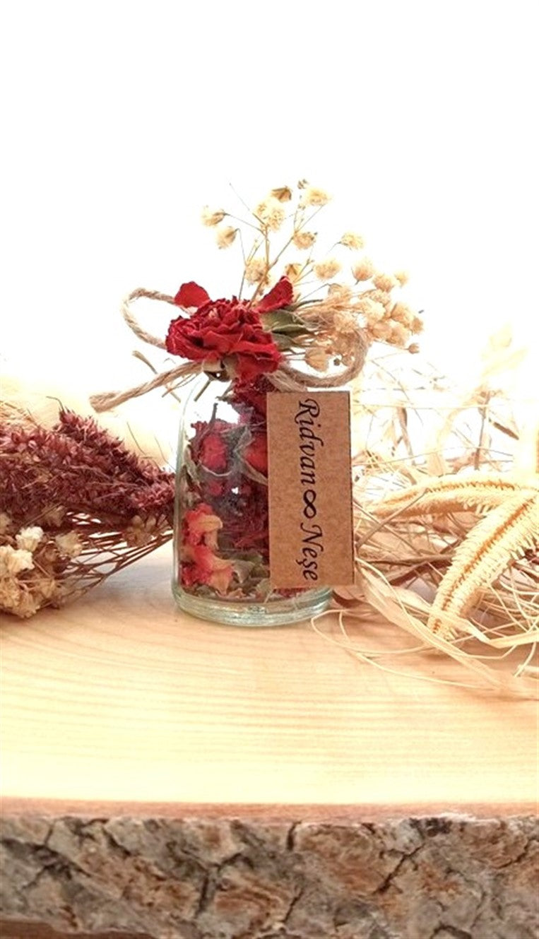 Personalisierte Glasfläschchen mit getrockneten Rosenknospen und Korkverschluss