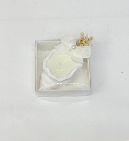 Weiße Muschelkerze in transparenter Box mit Schleife und Trockenblumen
