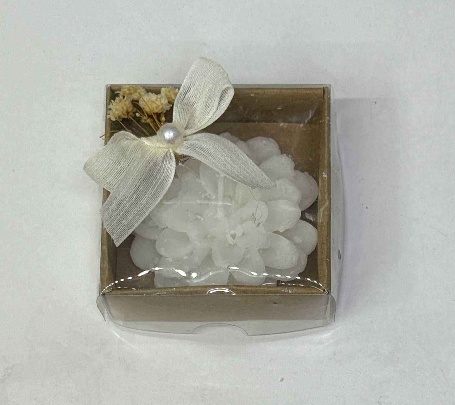 Weiße Blütenkerze in brauner Geschenkbox mit Schleife und Trockenblumen