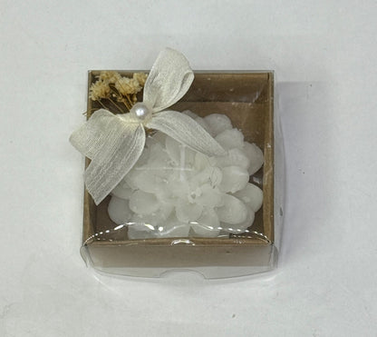 Weiße Blütenkerze in brauner Geschenkbox mit Schleife und Trockenblumen