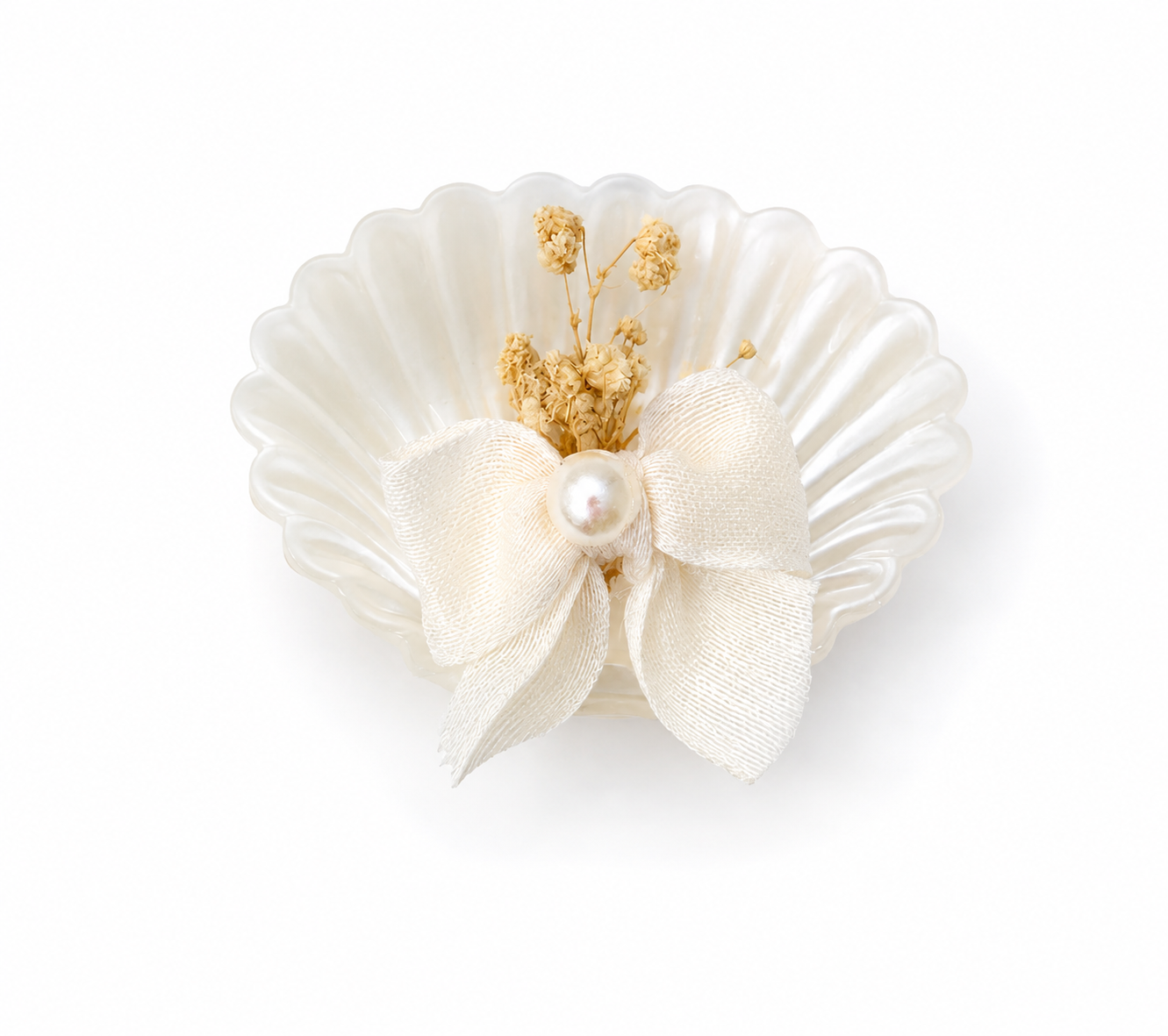 Weiße Kerze in Muschelform mit Schleife und Trockenblumen